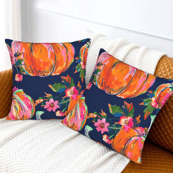 Set of two velvet pillow covers with navy large pumpkins and small flowers, styled on a sofa