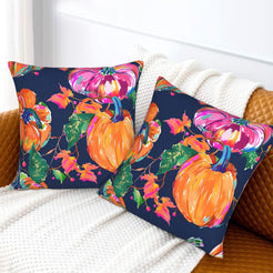 Set of two velvet pillow covers with navy mixed fall leaves and pumpkins, styled on a sofa