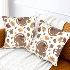 Set of two velvet pillow covers with cream turkeys and autumn leaves, styled on a sofa