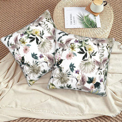 Tropical velvet pillow covers with white cranes and tropical flowers, styled on a woven chair