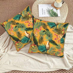 Tropical velvet pillow covers with mustard palms and birds, styled on a woven chair