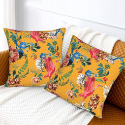 Tropical velvet pillow covers with mustard parrots and flowers, styled on a sofa