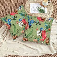 Tropical velvet pillow covers with sage parrots and flowers, styled on a woven chair