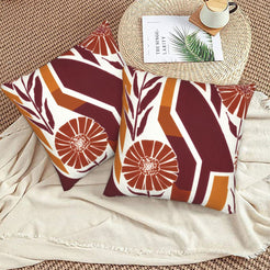 Fall velvet pillow covers with burgundy geometric stripes and orange flowers, styled on a beige sofa