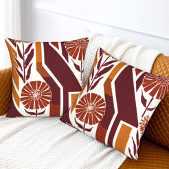 Fall velvet pillow covers with burgundy geometric stripes and orange flowers, styled on a white sofa