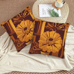 Fall velvet pillow covers with burgundy line-art flowers and gift-box shapes, styled on a beige sofa