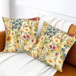 Velvet pillow covers with dense blue, yellow and pink meadow flowers, styled on a cream sofa