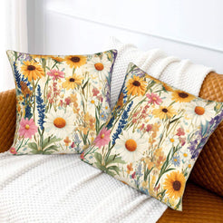 Velvet pillow covers with orange daisies and delicate meadow stems, styled on a cream sofa
