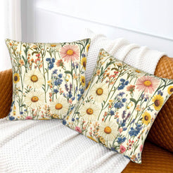 Velvet pillow covers with white daisies and airy blue wildflowers, styled on a cream sofa