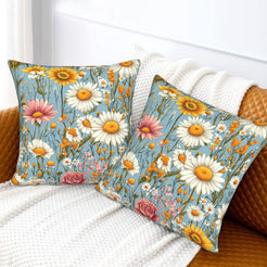 Velvet pillow covers with white daisies and pink flowers on blue, styled on a cream sofa
