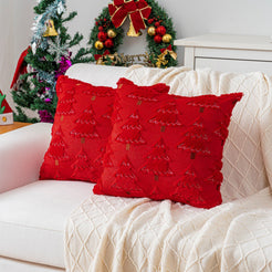 Quilted polyester pillow covers with raised dark green trees on red, styled on a cream sofa