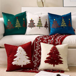 Assorted embroidered Christmas tree velvet pillow covers styled on a sofa