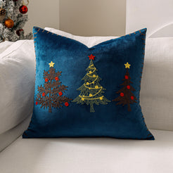 Blue velvet pillow cover with embroidered Christmas trees on a sofa