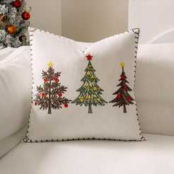 Ivory velvet pillow cover with embroidered Christmas trees on a sofa