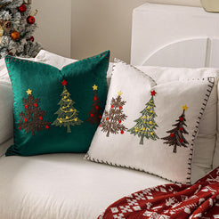Green and ivory embroidered Christmas tree velvet pillow covers on a sofa