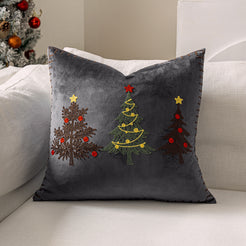 Gray velvet pillow cover with embroidered Christmas trees on a sofa