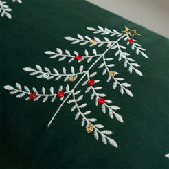 Close-up of embroidered Christmas tree branches on green velvet