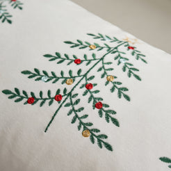 Close-up of embroidered Christmas tree branches on ivory velvet