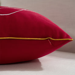 Hidden zipper and gold piped edge detail on a red velvet lumbar pillow cover