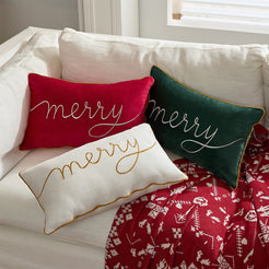 Red, green and ivory embroidered Merry velvet pillow covers styled on a sofa