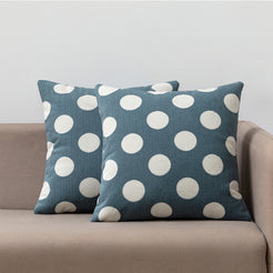 Loop-pile textured polyester pillow covers with raised white polka dots on dusty blue, styled on a neutral sofa