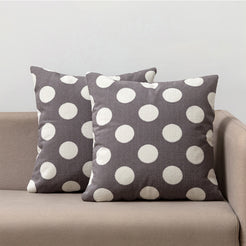 Loop-pile textured polyester pillow covers with raised white polka dots on gray, styled on a neutral sofa