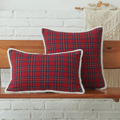 Red tartan woven cotton-polyester blend square and lumbar pillow covers on a bed