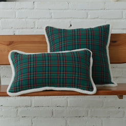 Green tartan woven cotton-polyester blend square and lumbar pillow covers on a bed