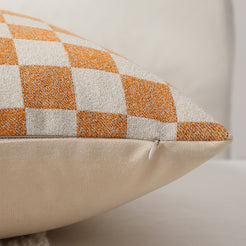 Side view of an orange checkerboard chenille pillow cover with hidden zipper