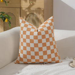 Orange and ivory checkerboard chenille square pillow cover on a sofa