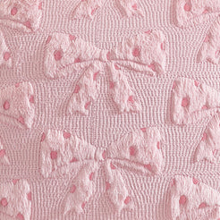 Close-up of raised bow embroidery on embroidered woven polyester pillow cover with raised pink bows
