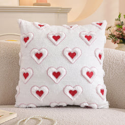 Embroidered woven polyester pillow covers with raised red hearts on white, styled on a cream sofa