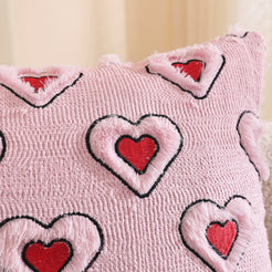 Close-up of raised outlined heart embroidery on embroidered woven polyester pillow cover with outlined red hearts on pink