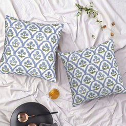 Set of two water-resistant pillow covers with blue and green block-print-style florals, styled on a bed