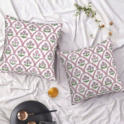 Set of two water-resistant pillow covers with pink and green block-print-style florals, styled on a bed