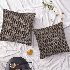 Set of two water-resistant pillow covers with dark brown small floral motifs, styled on a bed