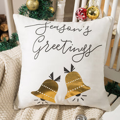 short-pile plush polyester pillow cover with Season’s Greetings lettering and gold bells, shown beside a Christmas tree