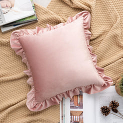 Blush pink velvet polyester pillow cover with ruffled edge, shown at an angle