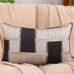 Black, beige and gold jacquard-woven polyester lumbar pillow cover styled on a sofa