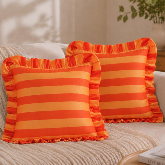 Orange and coral striped velvet polyester pillow covers with ruffled edges, displayed as a pair