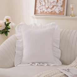 White washed cotton pillow cover with ruffled edges on a sofa